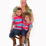 an image of a woman with her two sons sitting on a stool