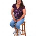 an image of a woman sitting on a stool and smiling