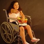photo of a girl in a wheelchair pointing