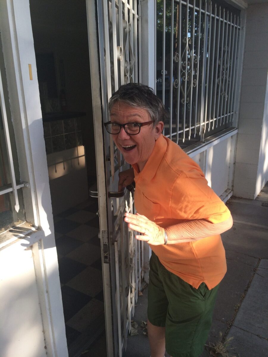 Tina Opening Door To Brand New Building Wearing Orange Shirt And Green Shorts Opening Front Door