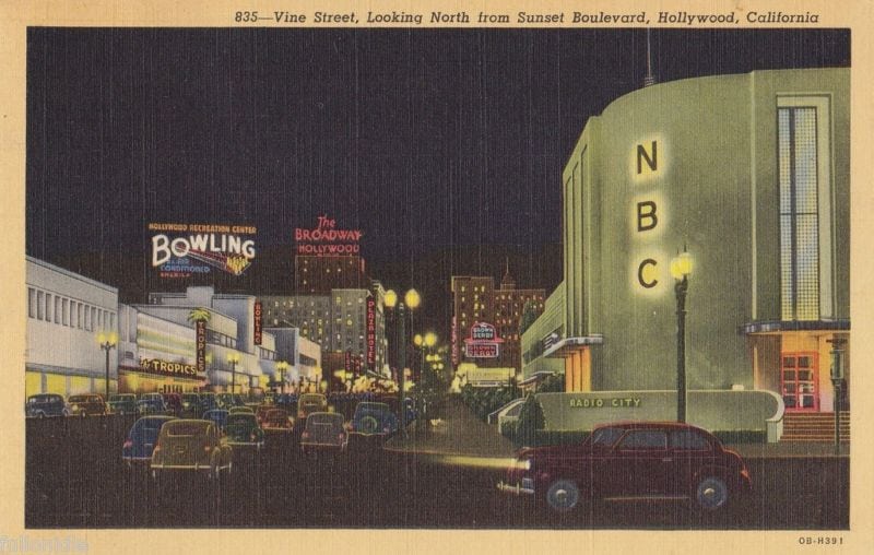Old Picture Of NBC Radio Radio City Building At Night With Old Cars Driving On The Street In Front Of It