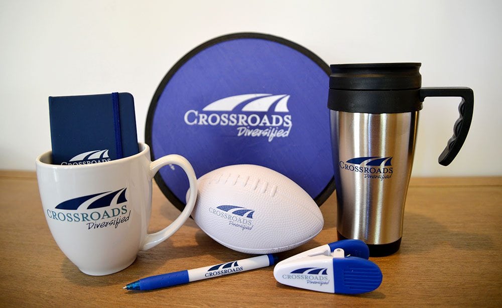 Crossroads Diversified swag, including a mug, foam football, magnet clip, pen, coffee thermos, and notebook
