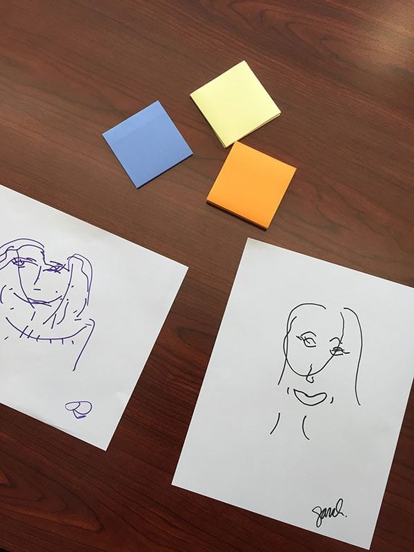 an image of some post-its on the page and two contour line sketches of human faces