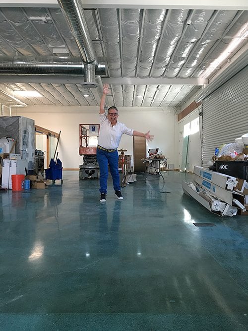 an image of Tina Reynolds jumping up and down on the brand new floors of our new warehouse office