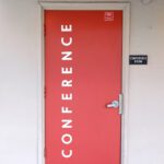 Red School Door With Conference Written On Front With White Letters