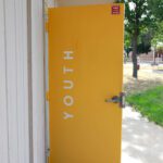 Yellow School Door With Youth Written On Door That Is Open