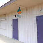 Sign Of Stem Hanging Over Two Purple Doors At La Familia School