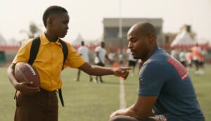 A child with a coach on the football field
