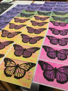 A bunch of yellow, purple, green, and pink butterfly prints that Jill made
