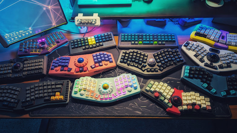 A top down photo of a desk with many keyboards arranged on it