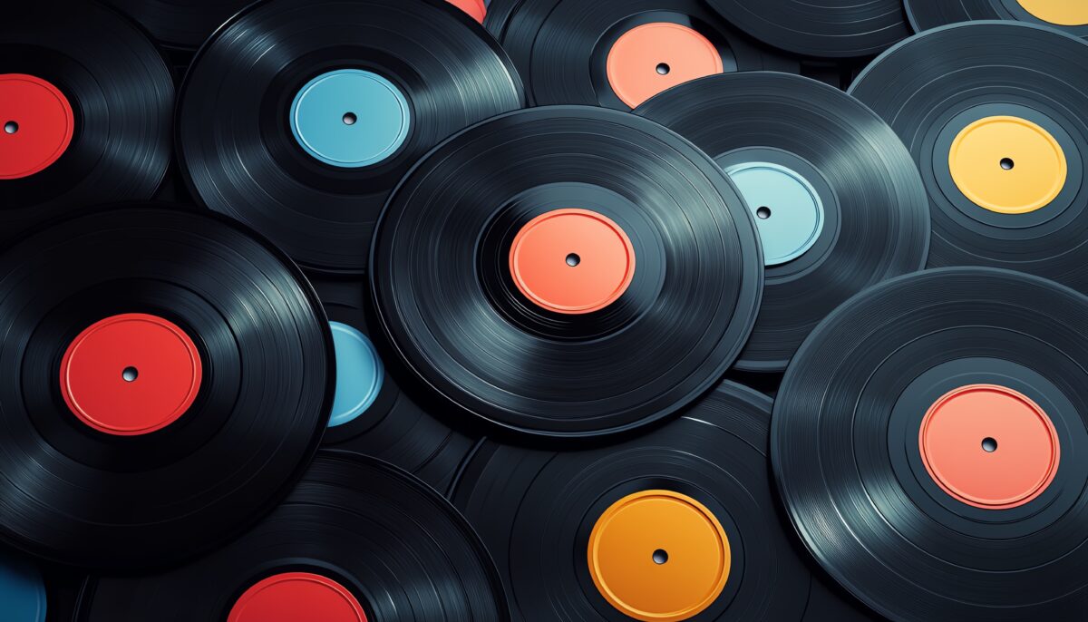 Records laying in a pile with colorful labels in the center.