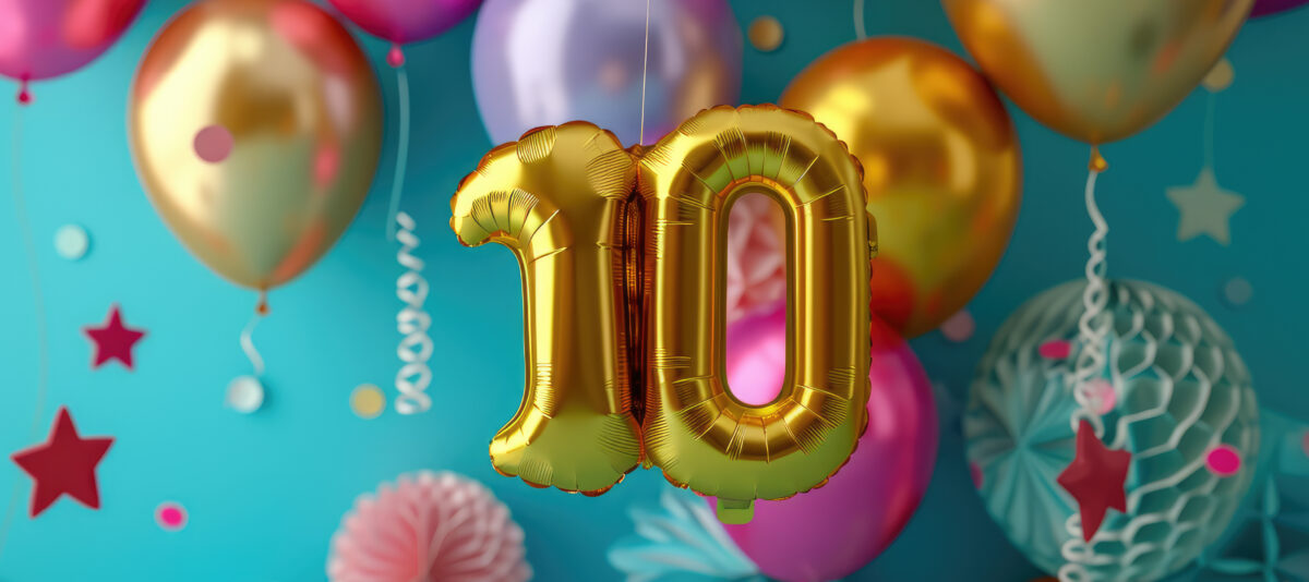 Balloons with metallic colors floating behind a mylar balloon in the shape of the number 10