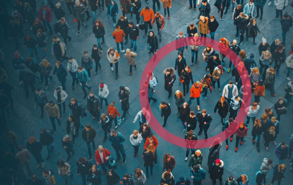 An aerial photo of a crowd of people in a large public space with a red circle drawn around a small group of people